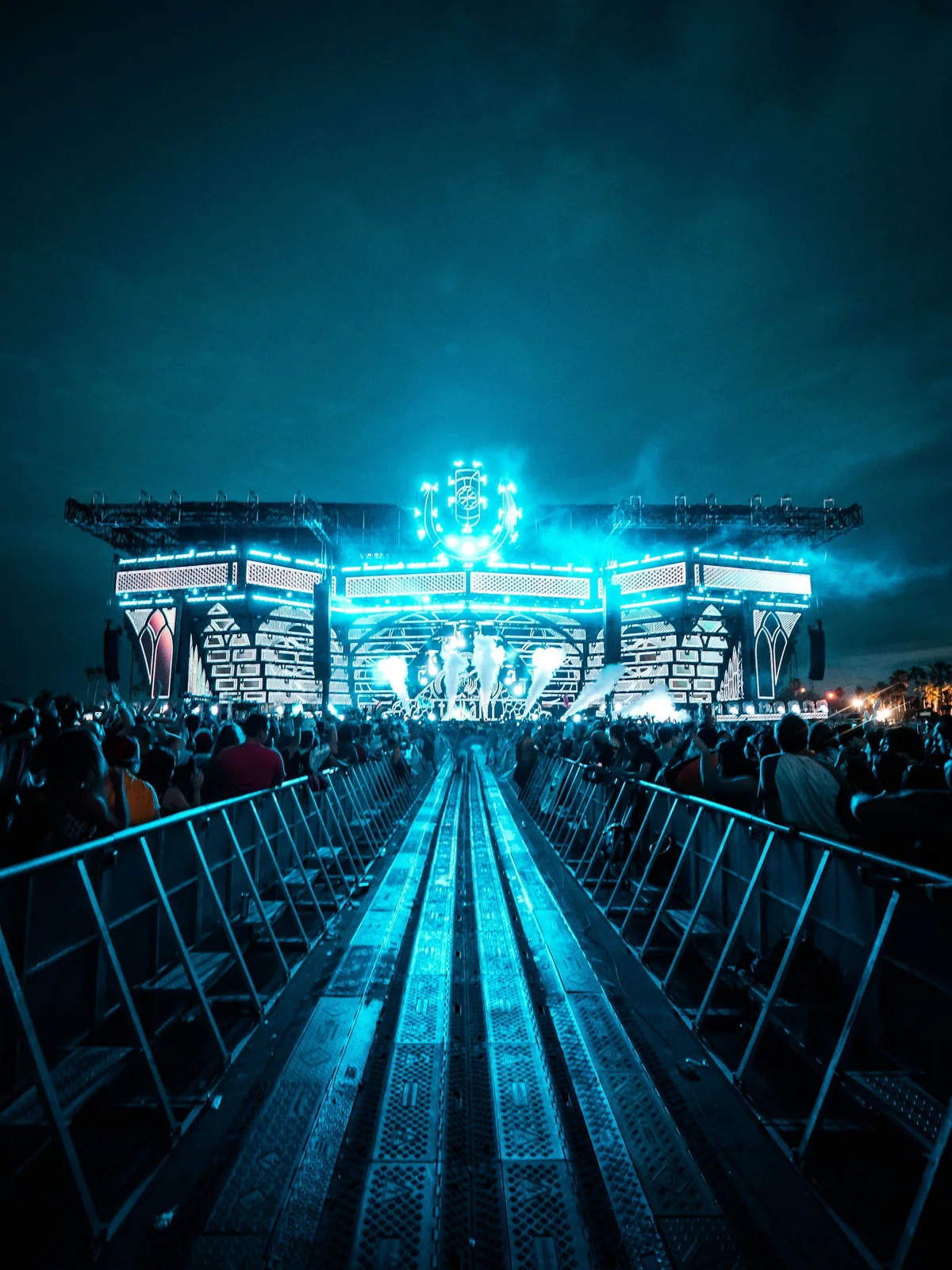 An outdoor music festival stage illuminated in blue at night