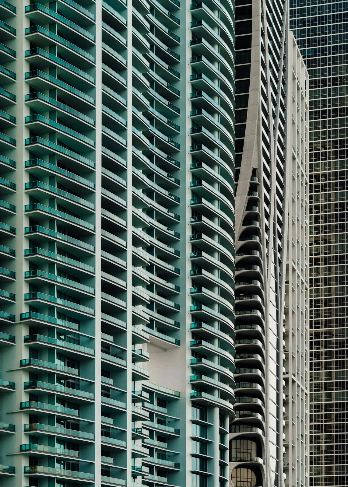 Condominium tower with glass windows and green balcony railings